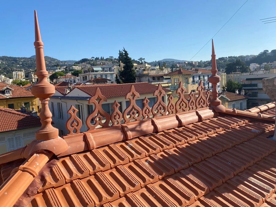 Détail d'un faîtage de toiture avec épi décoratif en terre cuite