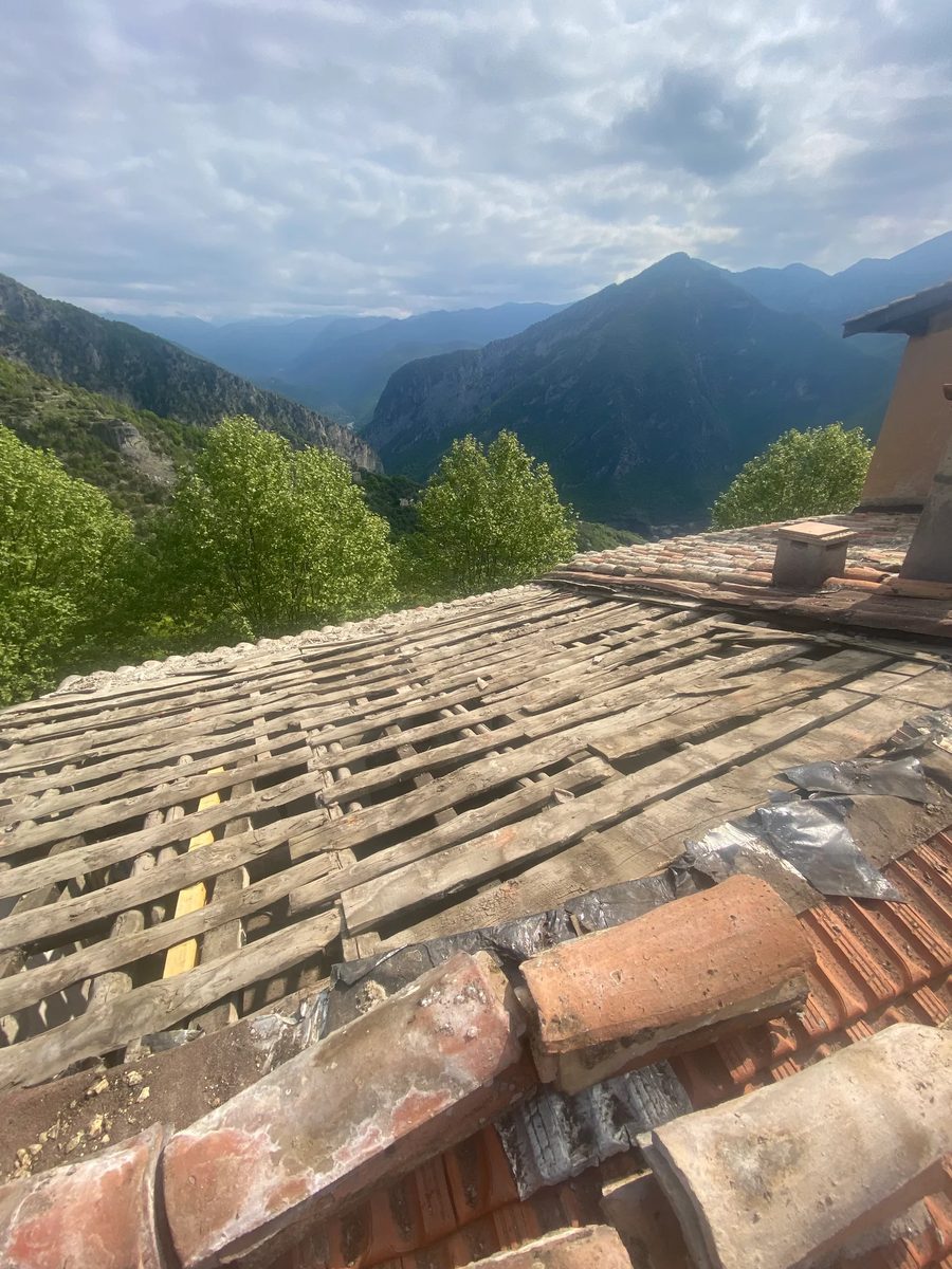 Toiture ancienne aux tuiles usées, examinée avant chiffrage d'une rénovation